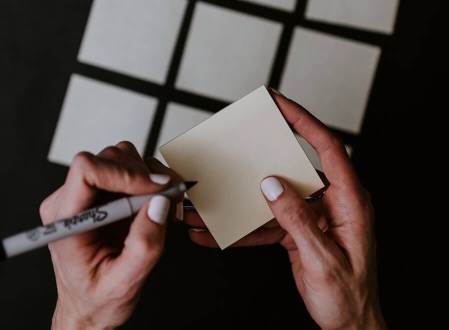 personne ecrivant du contenu sur des post it